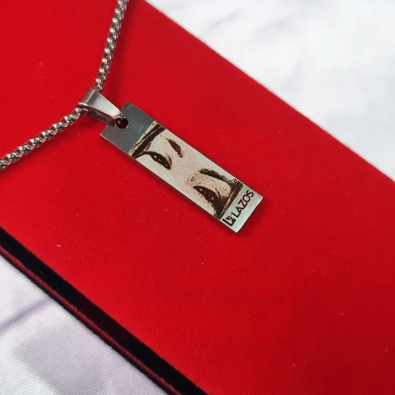 Dije rectangular plateado con fotograbado de ojos presentado en estuche rojo