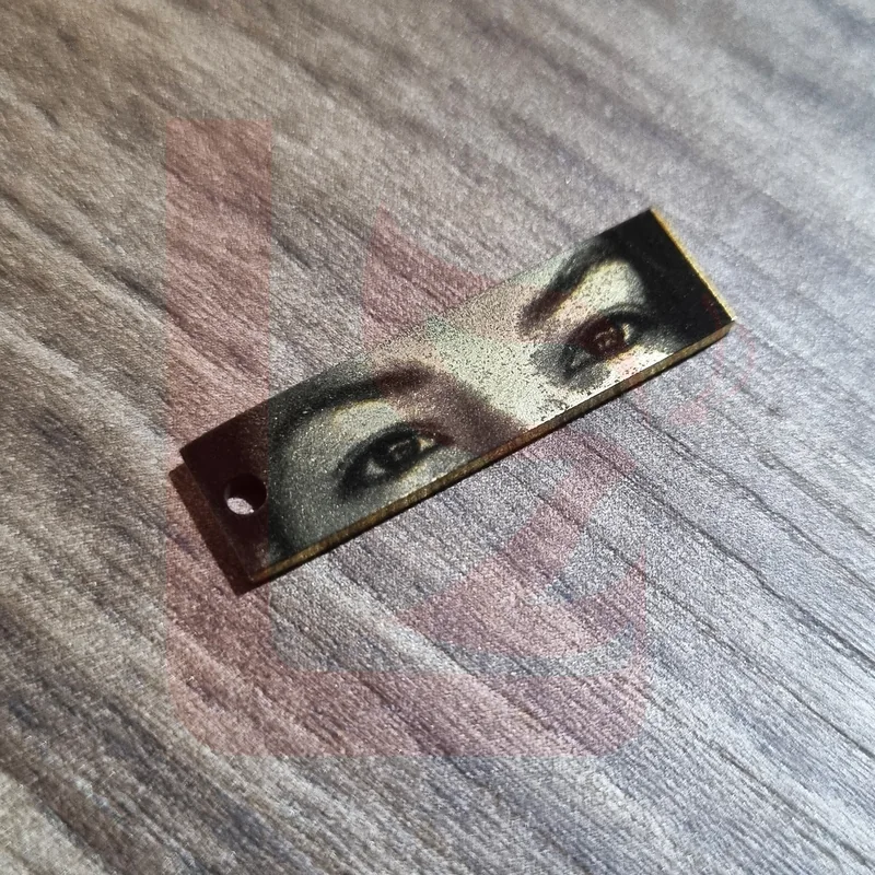 Placa rectangular dorada con fotograbado de ojos