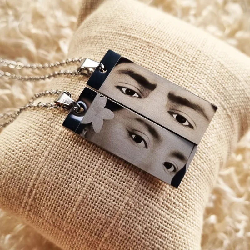 Pareja de dijes rectangulares plateados con fotograbado de miradas
