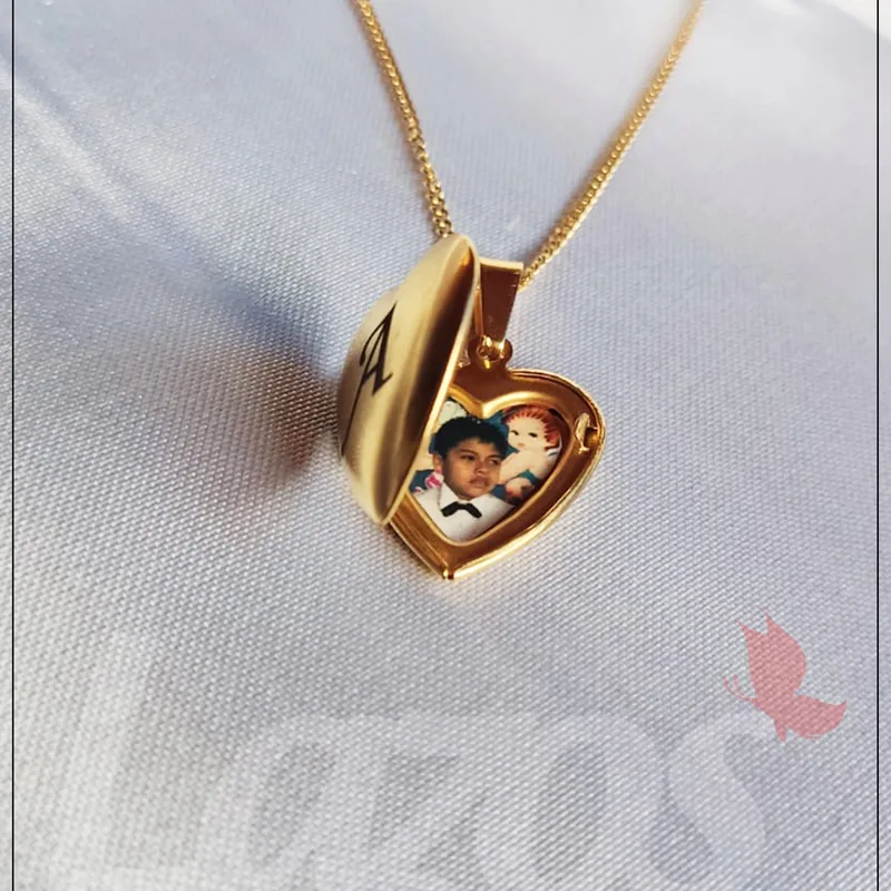 Relicario corazón dorado abierto con fotografía de infancia